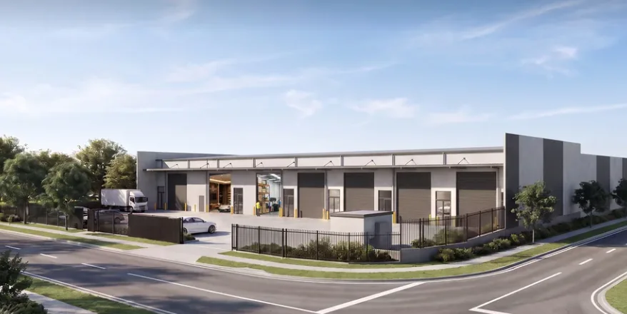 Corner-site industrial development in use — a delivery truck at an open roller door, precast panel walls and hardstand.